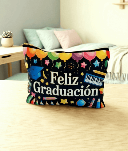 Bolsa multiusos de color negro con diseño de dibujos multicolores y la frase "FELIZ GRADUACIÓN" con letras blancas, en superficie de madera clara con un fondo de habitacion juvenil con colores pastel.