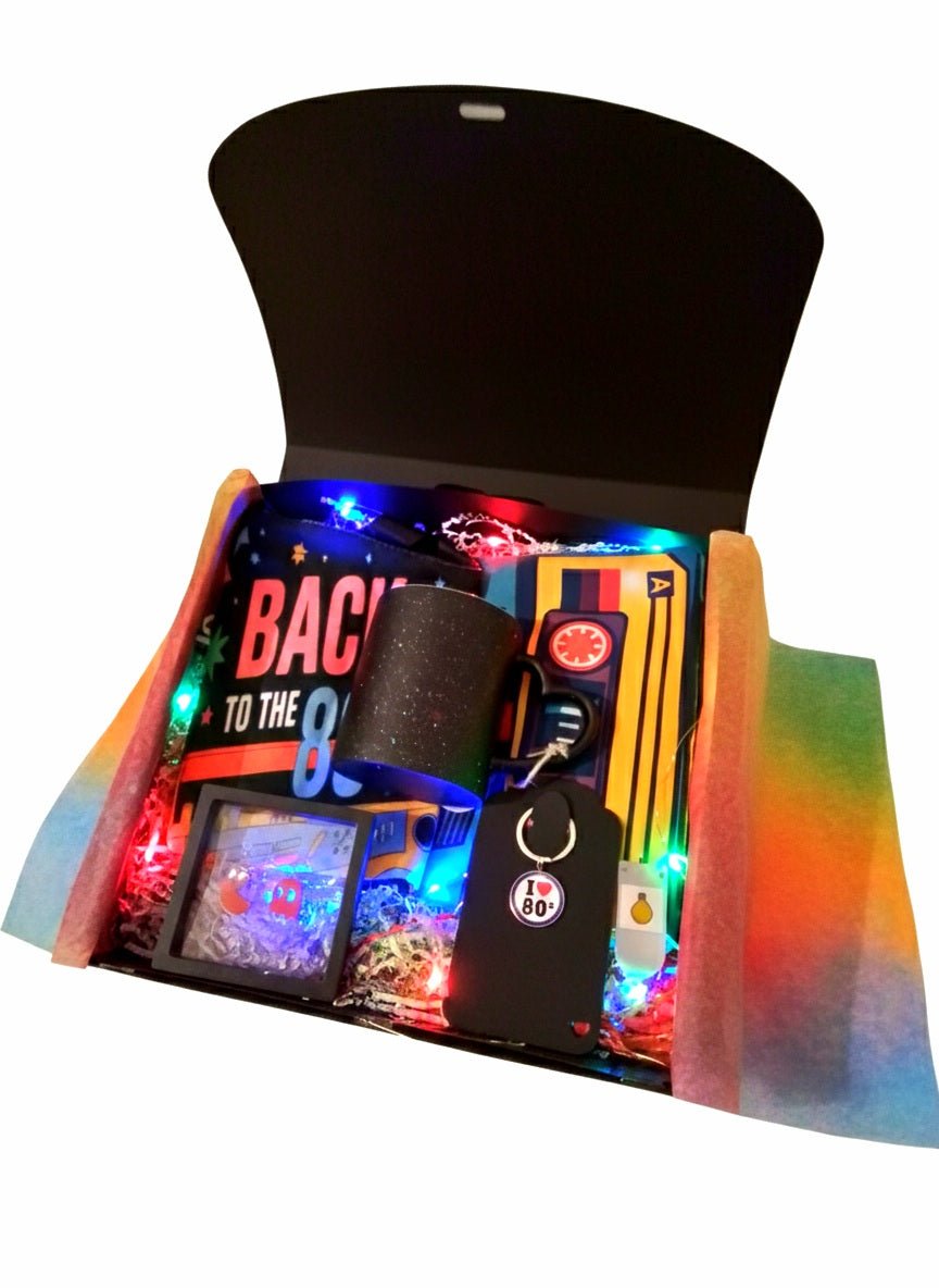 Caja de regalo negra con articulos y accesorios de diseño retro ochentero de colores fluor y luces led multicolor.
