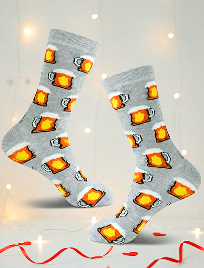 Par de calcetines grises con estampado de jarras de cerveza espumosa, flotando sobre fondo blanco con luces calidas y detalles rojos.