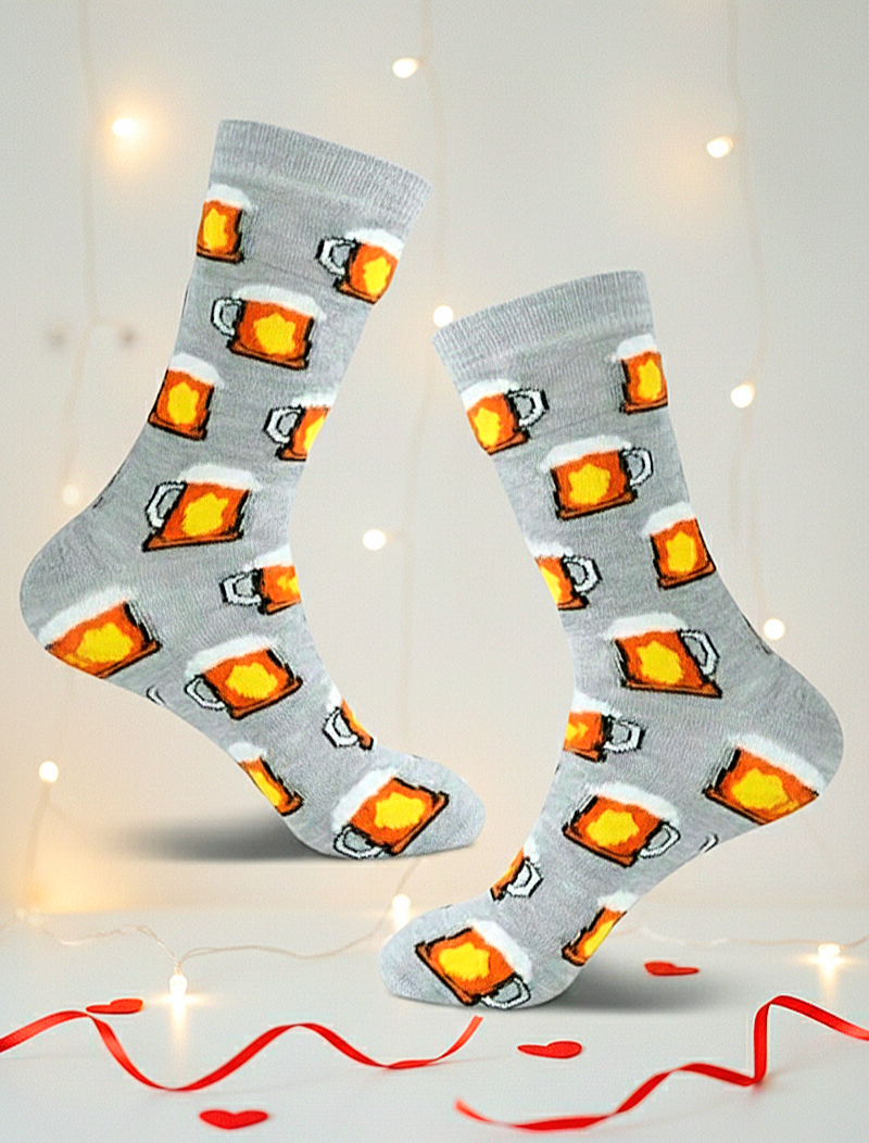 Par de calcetines grises con estampado de jarras de cerveza espumosa, flotando sobre fondo blanco con luces calidas y detalles rojos.