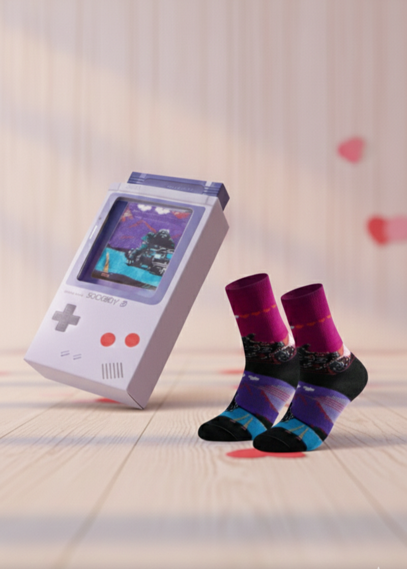 Calcetines con diseño pixel art de videojuegos  junto a su caja en forma de consola portatil gris.