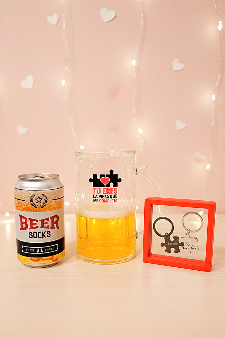 Los tres artículos de la BEERLY FIT BOX:  Una lata de Beer Socks, una jarra de cerveza enfriadora con el mensaje: Tu eres la pieza que me completa y un set de llaveros de piezas de puzzle