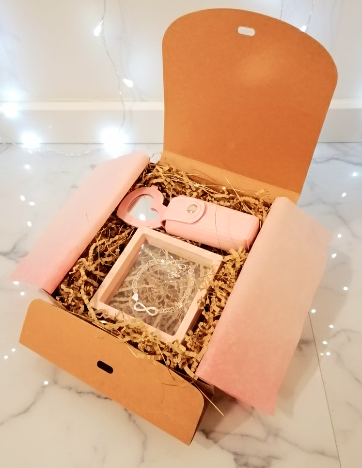 Caja de regalo abierta Infinity  Pink Box, con pulsera infinito, porta-labial rosa y espejo de corazón. 