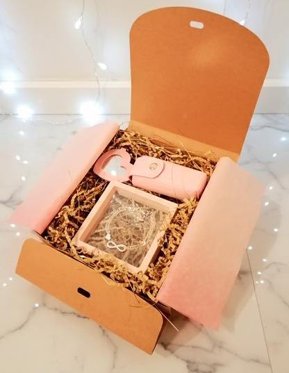 Caja de regalo abierta Infinity  Pink Box, con pulsera infinito, porta-labial rosa y espejo de corazón. 