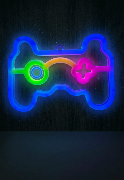 Lampara Led de neón con forma de mando de consola en colores azul, verde, naranja y rosa sobre pared oscura