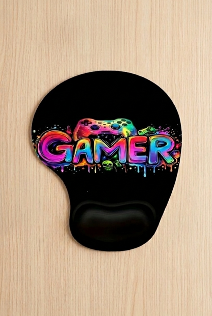 Mousepad negro con soporte ergonomico de muñeca y diseño de grafiti colorido que pone GAMER sobre fondo de escritorio de madera clara