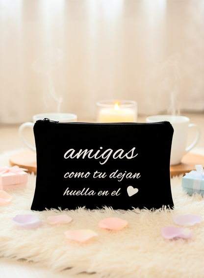 Neceser de tela negra con frase de amistad y detalle de corazón con fondo de luz de vela y colores pastel.