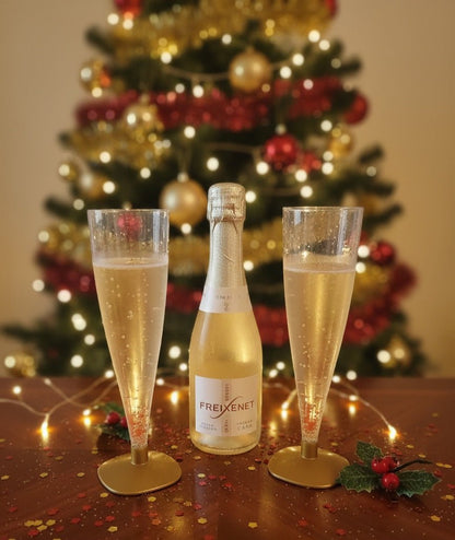 Mini botella de cava con copas en fondo Navideño.