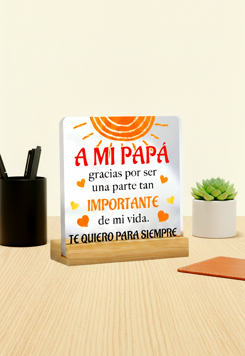 Placa de Metacrilato con base de madera y mensaje en español para papá sobre escritorio de madera clara.