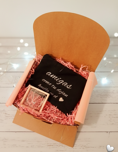 Caja de regalo para amigas con neceser negro y collar de Acero con simbolo de infinito presentado con fondo de virutas decpapel rosa.