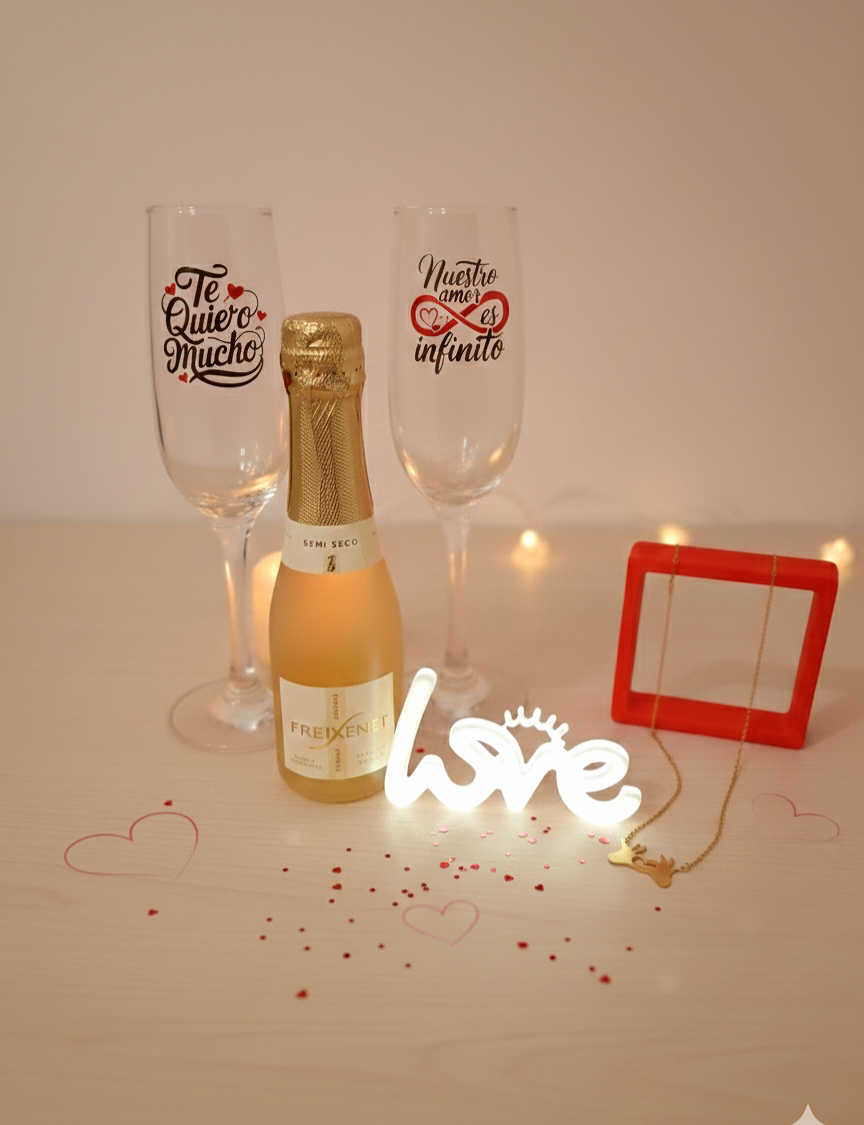 Botella de cava con dos copas personalizadas con frases romanticas en español  junto con luz led con la palabra LOVE y colgante dorado.