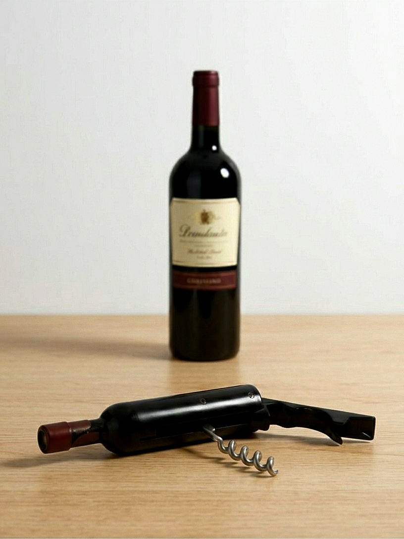 Sacacorchos metálico plegable con forma de botella de vino negra sobre fondo de madera clara.